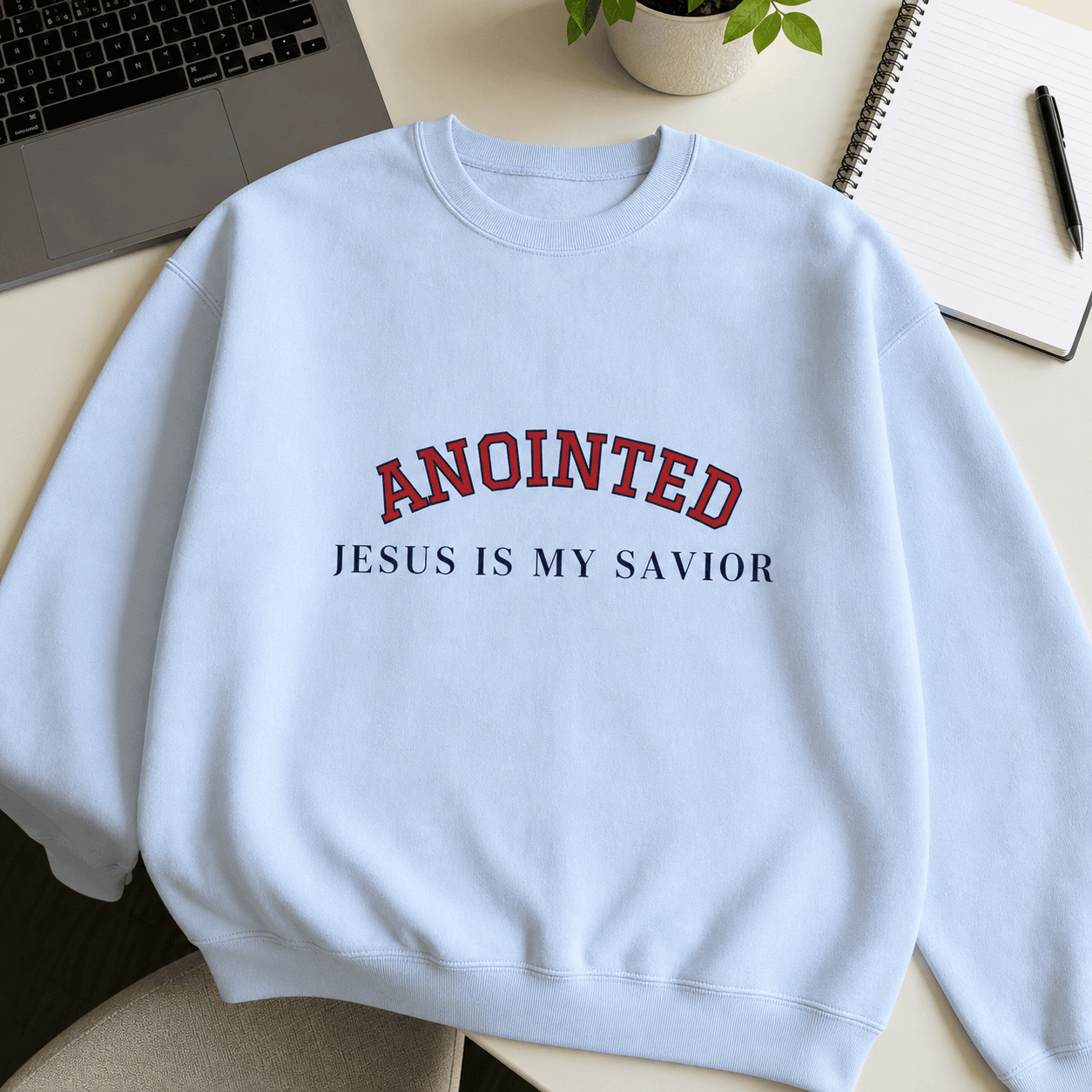 Light blue My Jesus sweatshirt laid flat on a desk